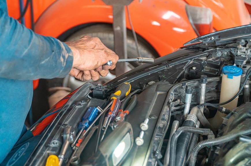 Mehaničar popravlja otvoren automobil